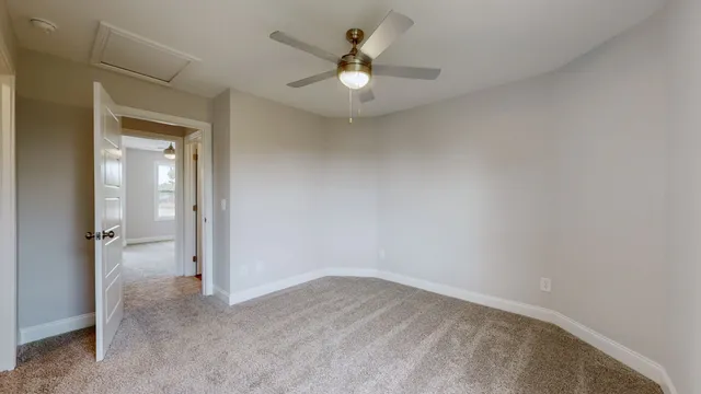 an empty room with a ceiling fan and a window