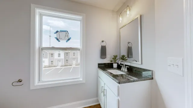 a bathroom with a granite countertop sink and a mirror