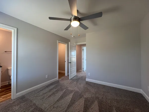 an empty room with a ceiling fan and a window
