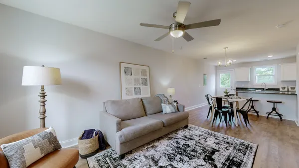 a living room with furniture and a dining area with kitchen view