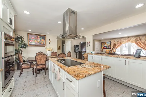 a kitchen with stainless steel appliances granite countertop a sink and a refrigerator
