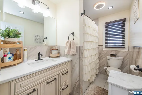 a bathroom with a sink a toilet and a mirror