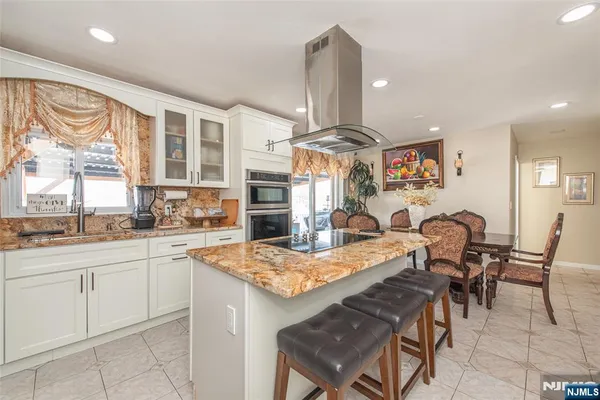 a open kitchen with stainless steel appliances granite countertop a sink and a refrigerator