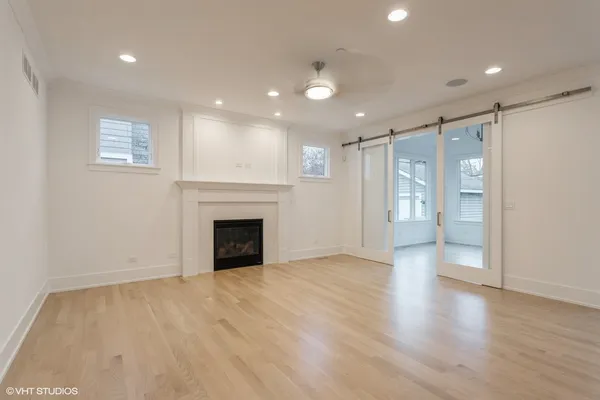 a view of an empty room with a window and a ceiling fan
