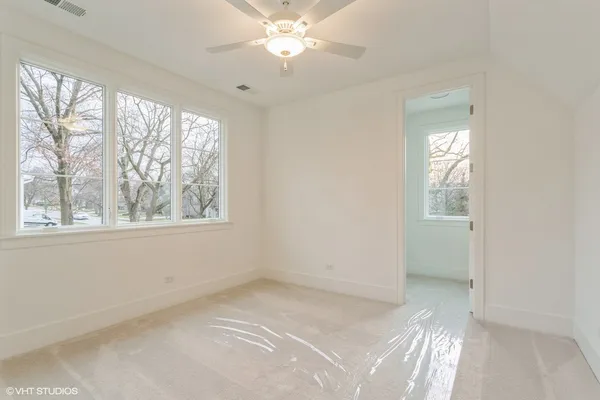 a view of a big room with wooden floor and windows