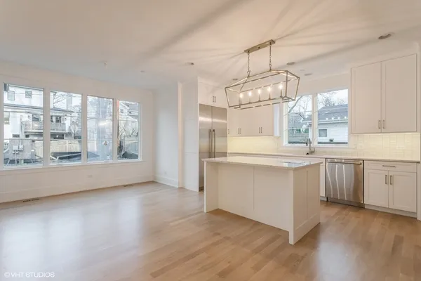 a kitchen with kitchen island granite countertop a sink cabinets a island and stainless steel appliances