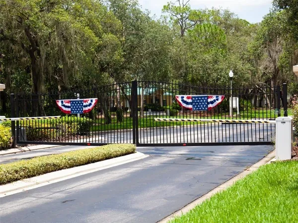 a view of a street with a fence and trees