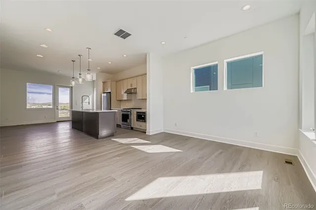 a view of kitchen and hall with wooden floor