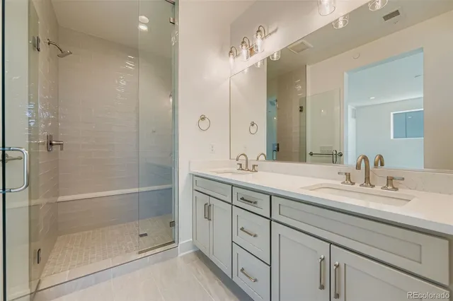 a bathroom with a shower tub double vanity sink and mirror
