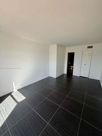 a view of an empty room with an empty space and a window