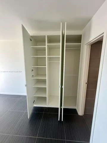a view of walk in closet with empty racks