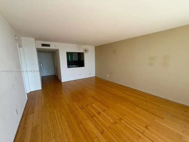 a view of a room with wooden floor and a ceiling fan