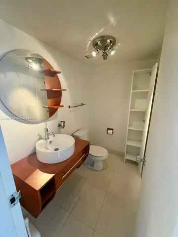 a bathroom with a sink mirror and toilet