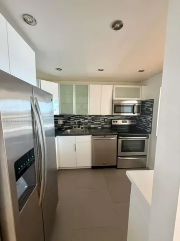 a kitchen with stainless steel appliances and refrigerator