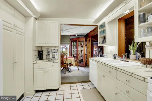 a kitchen with white cabinets and appliances