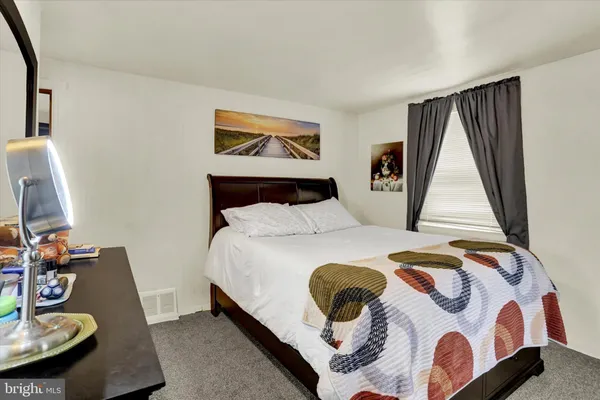 a bedroom with a bed and a lamp next to a window
