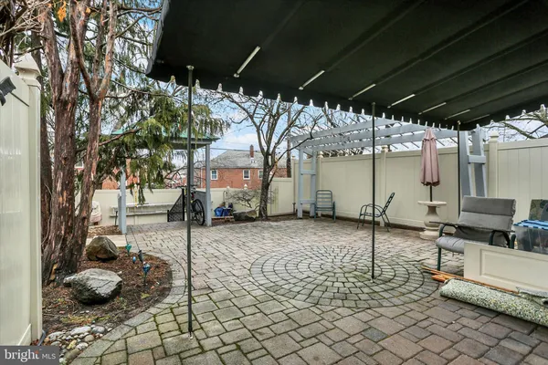 a view of a backyard with table and chairs and a large tree