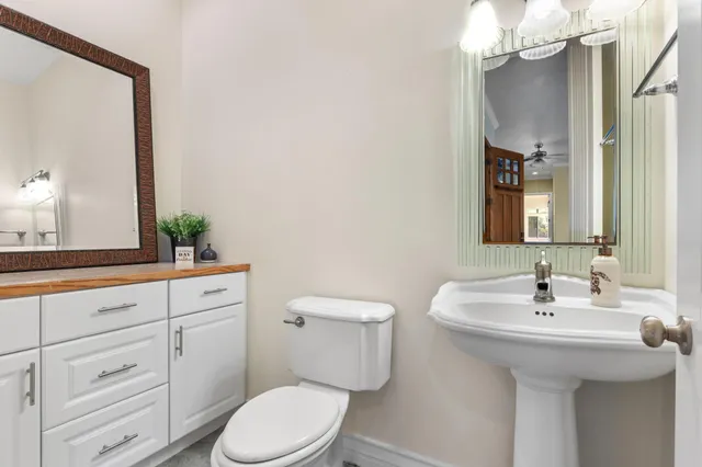 a bathroom with a toilet a sink and mirror
