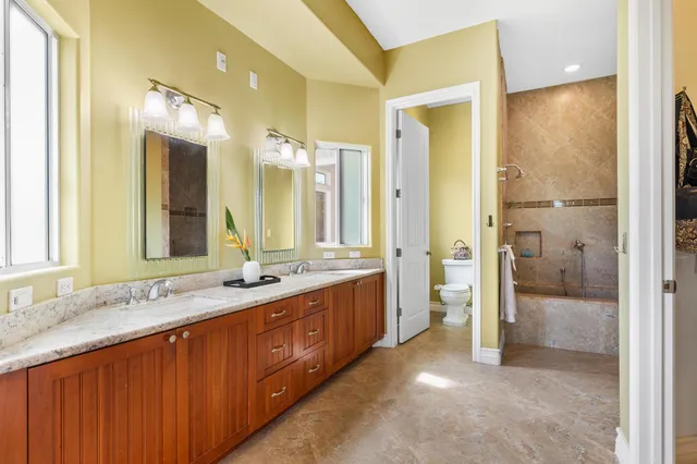 a bathroom with a double vanity sink and mirror with shower