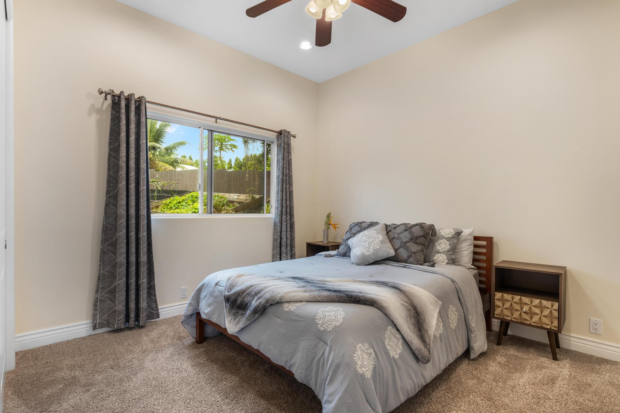28-256 Akaka Falls Road Honomu, HI 96728 - Photo 26 of 30 a bedroom with a bed and a chandelier