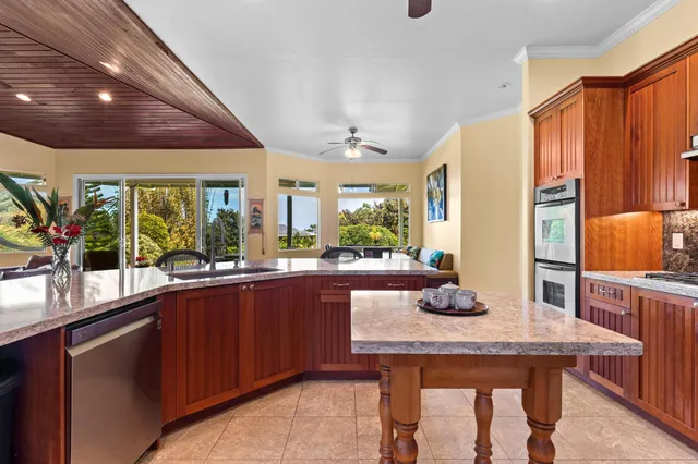 a kitchen with granite countertop kitchen island stainless steel appliances a sink table and chairs