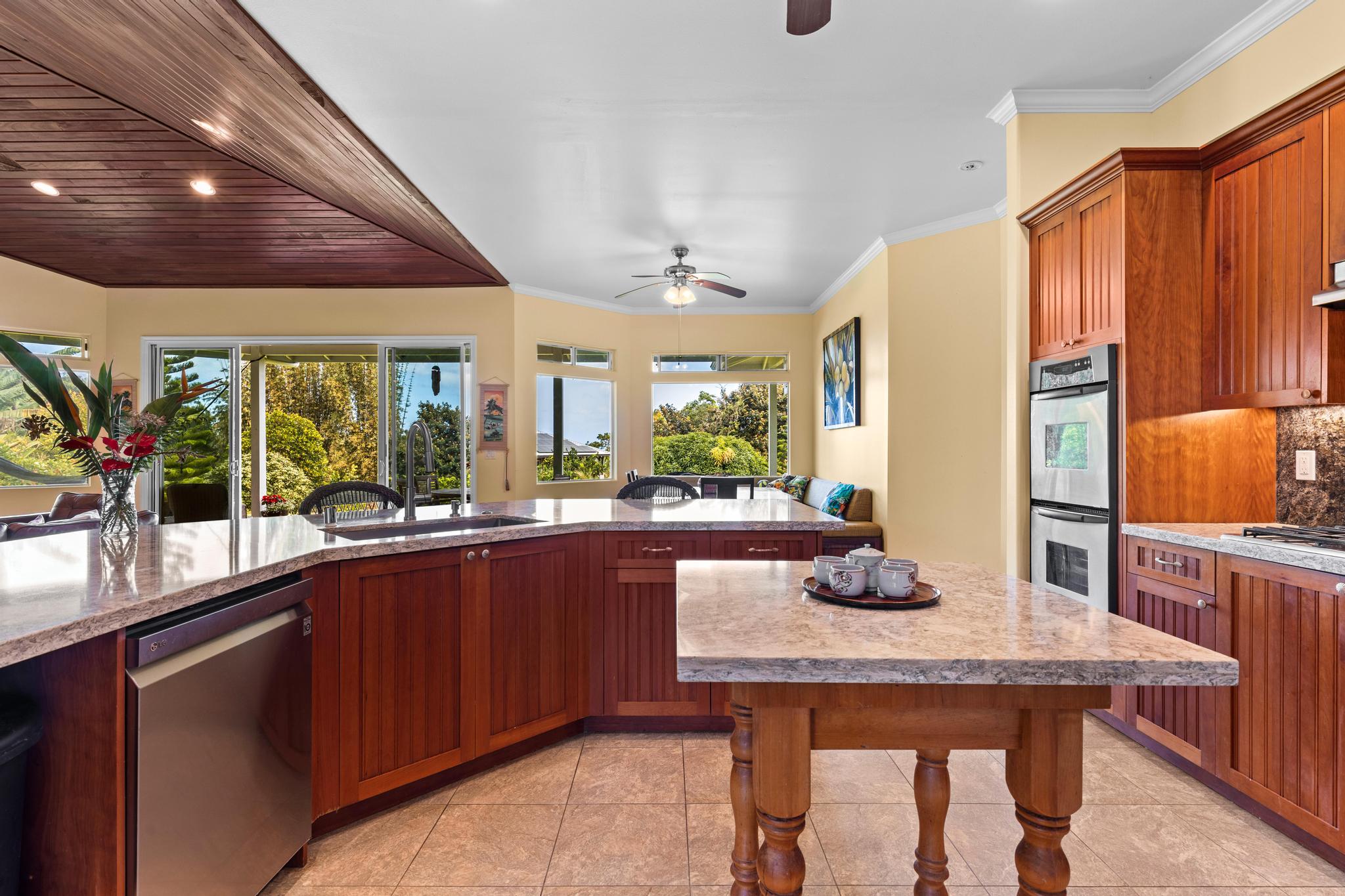 28-256 Akaka Falls Road Honomu, HI 96728 - Photo 7 of 30 a kitchen with granite countertop kitchen island stainless steel appliances a sink table and chairs