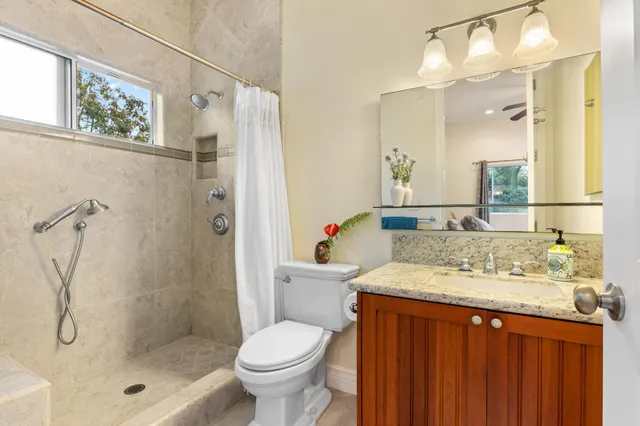 a bathroom with a granite countertop sink toilet and shower