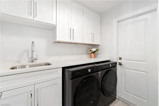 a utility room with sink dryer and washer