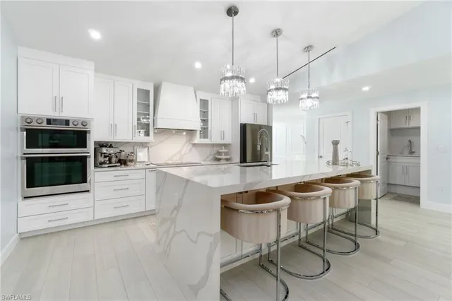 a kitchen with a dining table chairs stainless steel appliances and cabinets