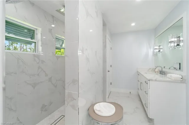 a bathroom with a granite countertop sink toilet and shower