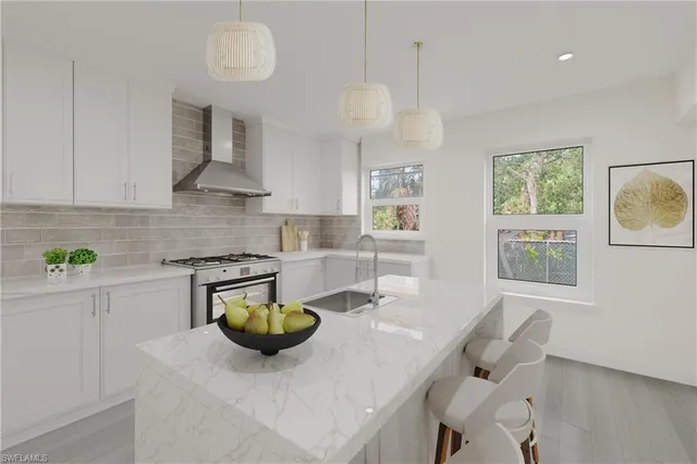 a kitchen with stainless steel appliances granite countertop a sink a stove and a wooden floors