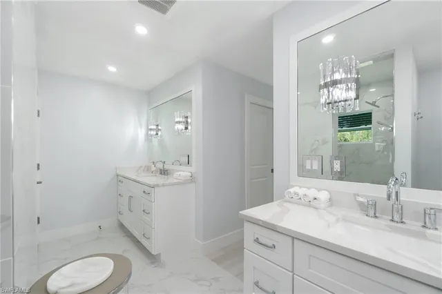a bathroom with a sink toilet double vanity and shower