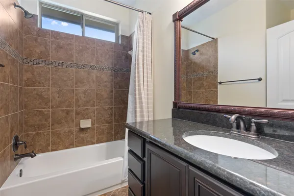 a bathroom with a granite countertop sink mirror toilet and bathtub