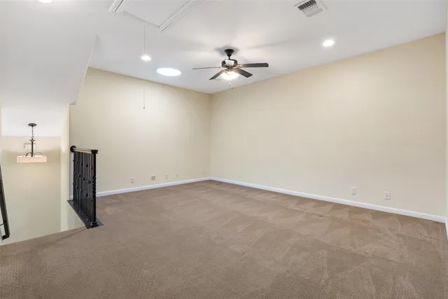 an empty room with a ceiling fan and a window