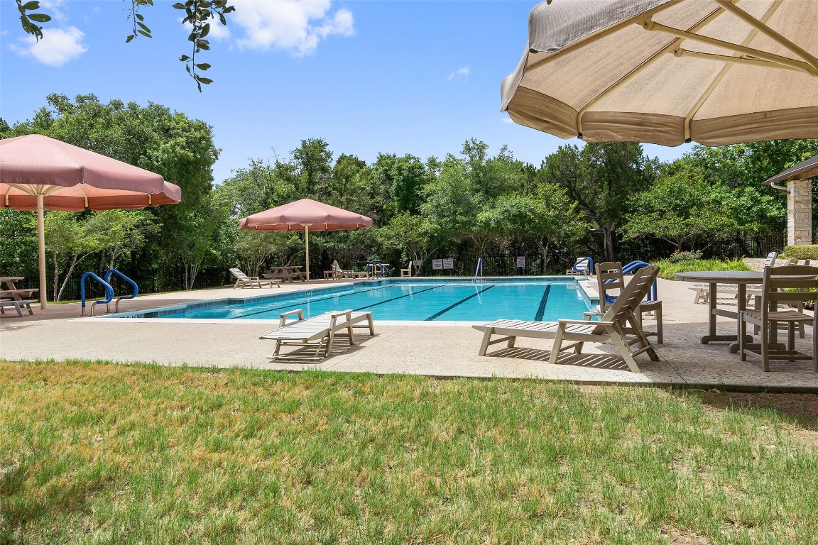 9412 Solana Vista Loop, Unit B Austin, TX 78750 - Photo 25 of 25 a view of a swimming pool with lawn chairs under an umbrella
