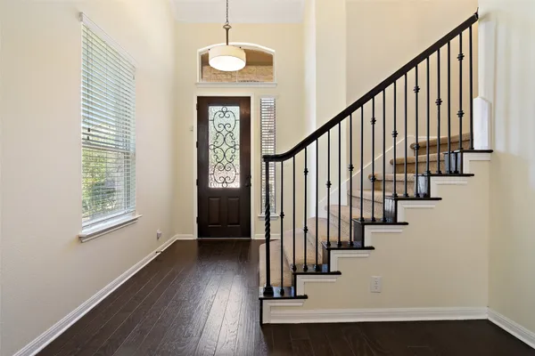 a view of an entryway with wooden floor and staircase