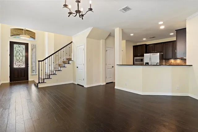 a view of a kitchen with wooden floor and electronic appliances