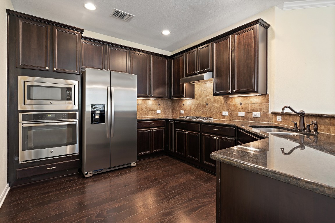 9412 Solana Vista Loop, Unit B Austin, TX 78750 - Photo 6 of 25 a kitchen with granite countertop a refrigerator and a sink