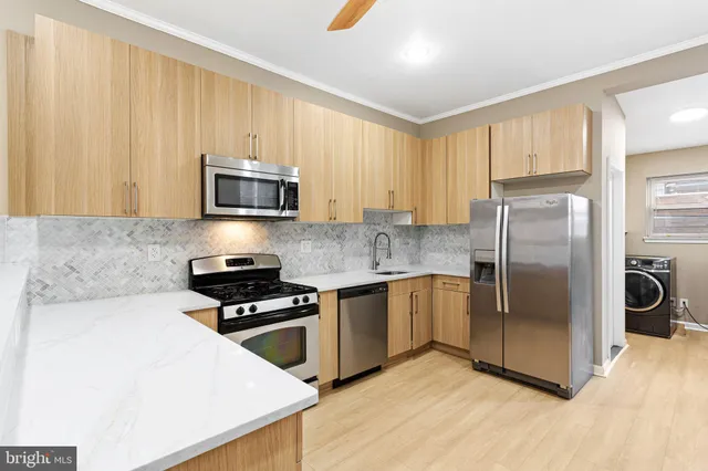 a kitchen with stainless steel appliances granite countertop a refrigerator stove top oven and sink