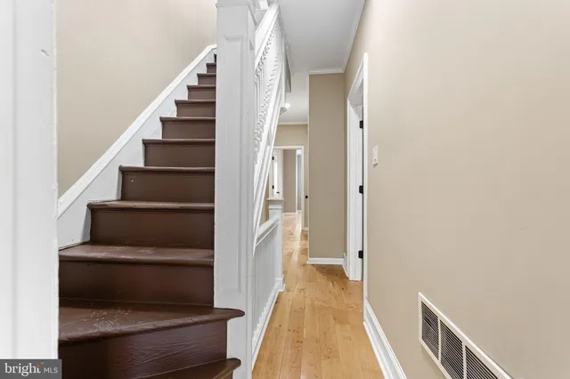 a view of a hallway with wooden floor and entryway