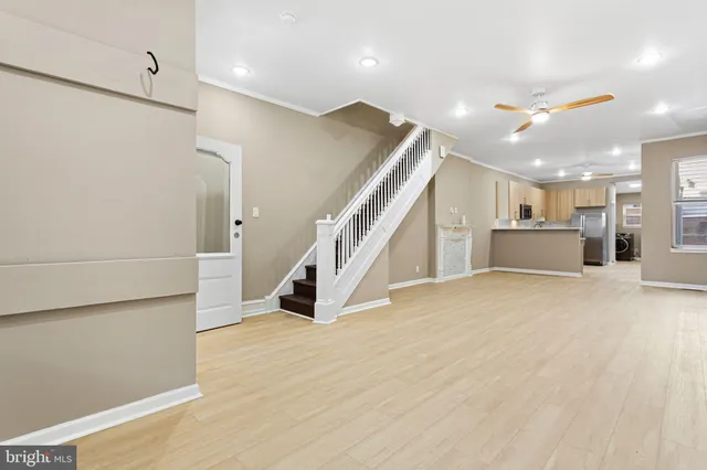 a view of an empty room with wooden floor and staircase