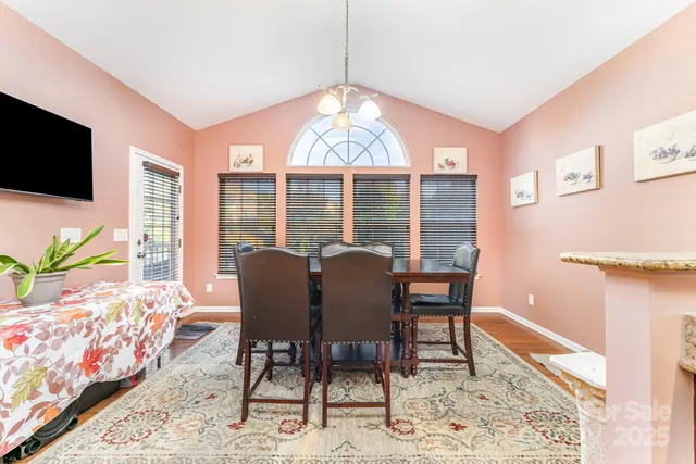 a dining room with furniture potted plants and wooden floor