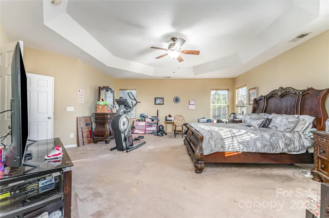 a spacious bedroom with bed and a chandelier