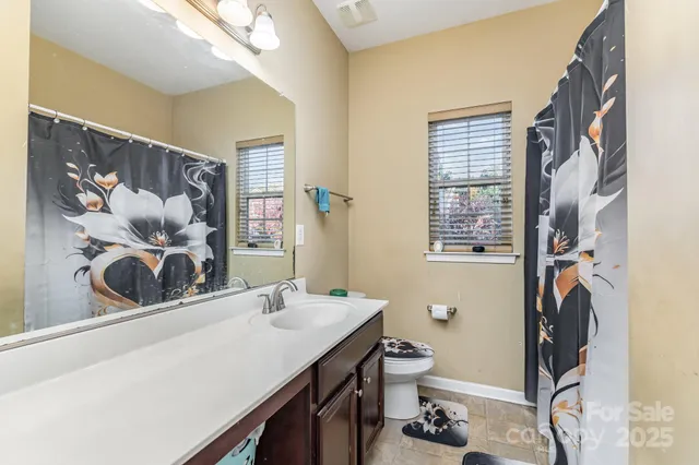 a bathroom with a sink a toilet and a mirror