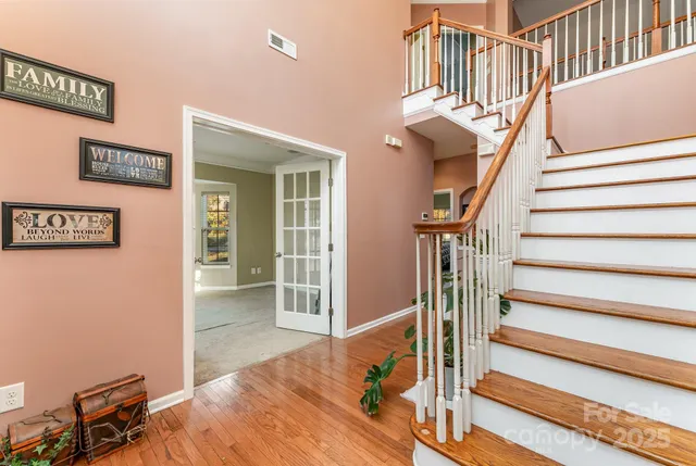 a view of entryway bedroom and hall with wooden floor