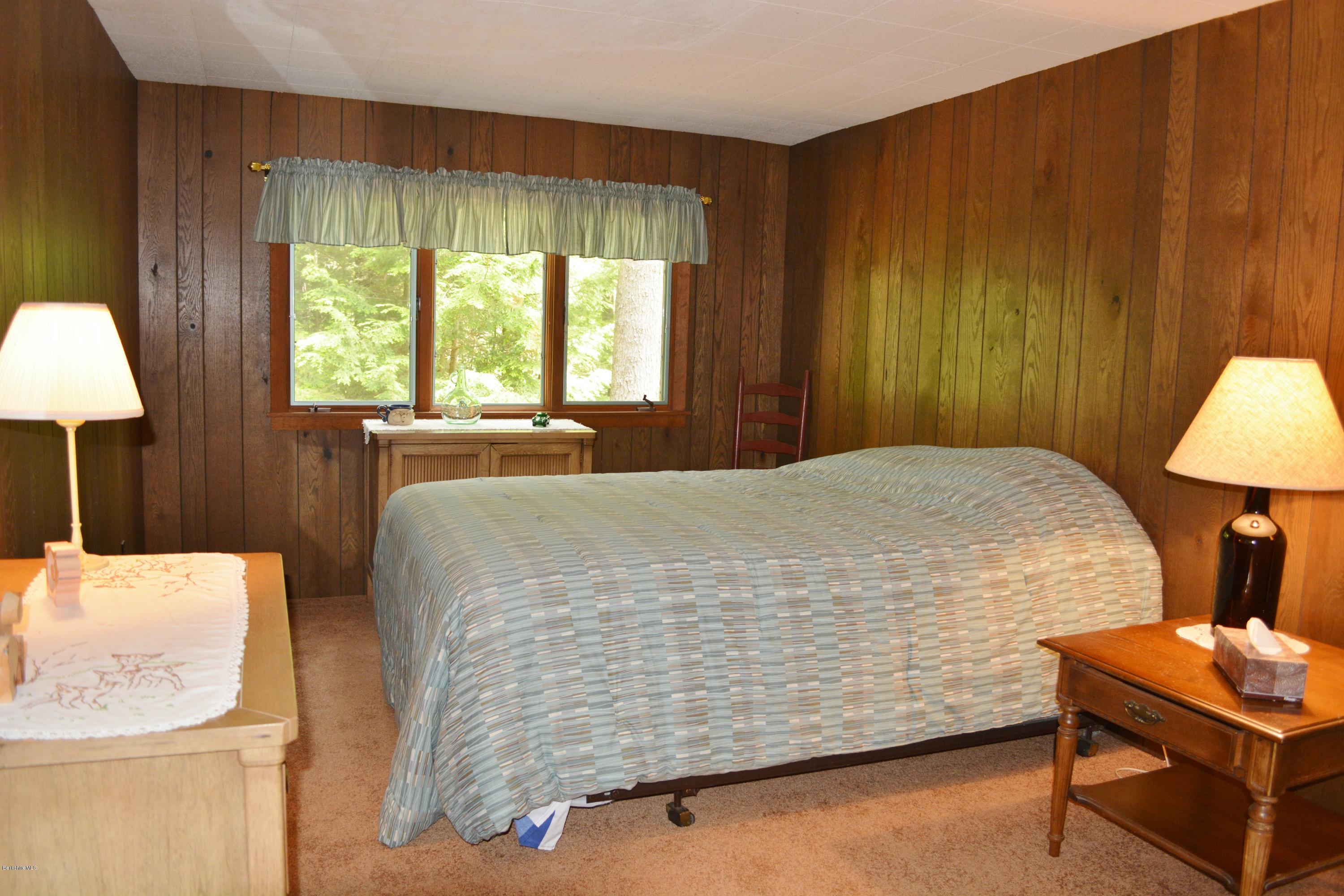 386 Pine Road Otis, MA 01029 - Photo 9 of 12 a bed sitting in a spacious bedroom next to a window