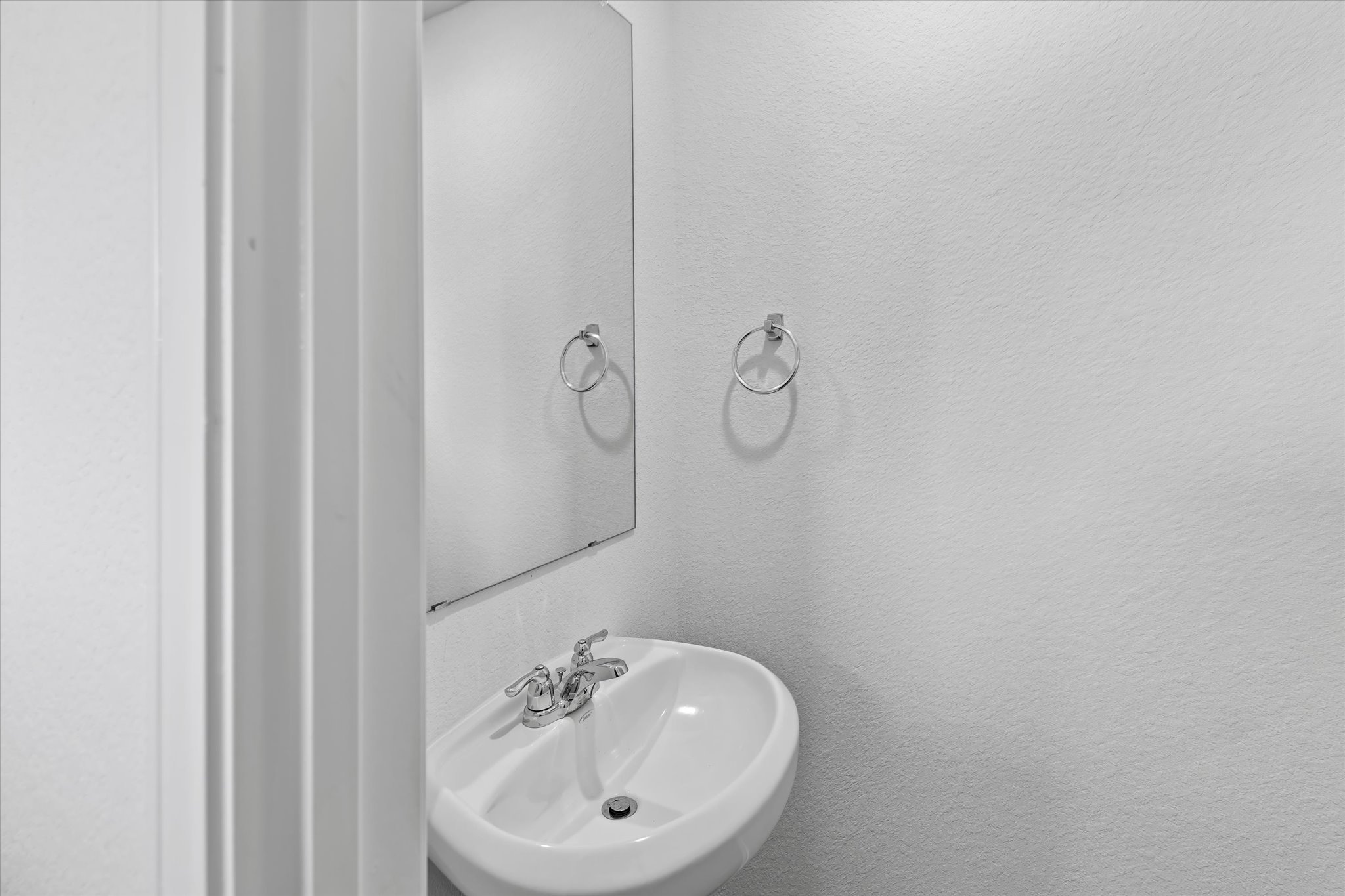 456 Sandringham Loop Kyle, TX 78640 - Photo 24 of 40 A well-maintained bathroom with a white basin sink and a mirror above.