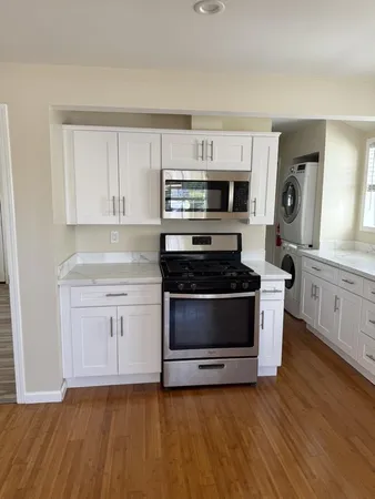 a kitchen with granite countertop a stove a microwave and a sink