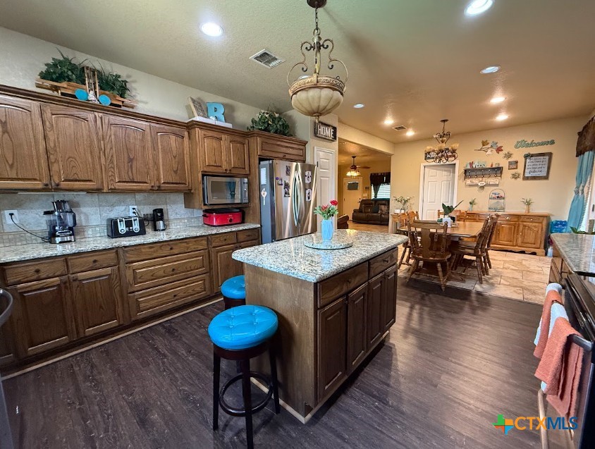 609 Highway 123 Stockdale, TX 78160 - Photo 11 of 26 a kitchen with a dining table chairs stainless steel appliances and cabinets