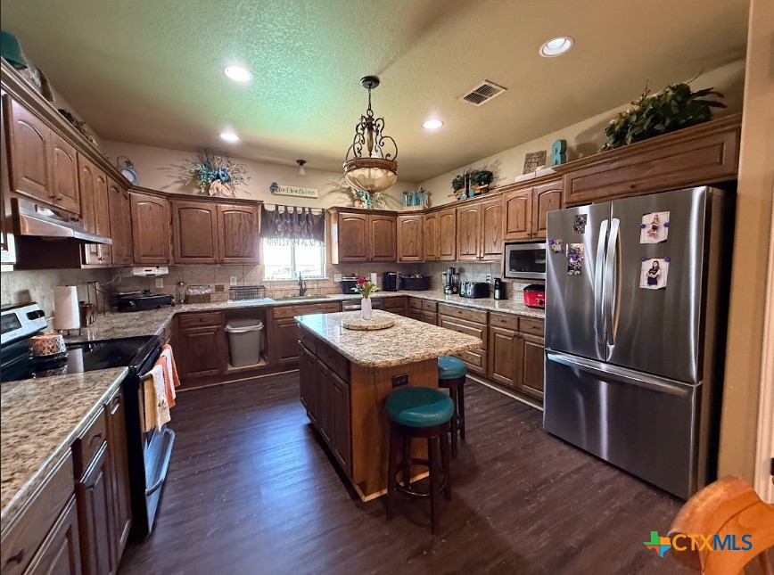 609 Highway 123 Stockdale, TX 78160 - Photo 8 of 26 a kitchen with kitchen island stainless steel appliances a sink cabinets and wooden floor